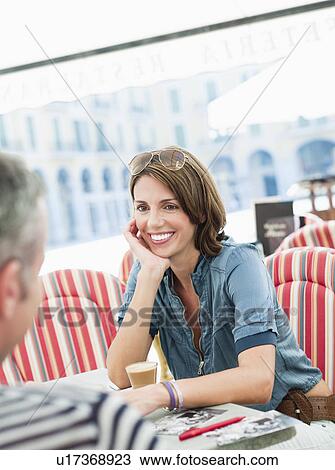 couple sitting in a city cafe smiling View Large Photo Image Stock Image - couple sitting in a city cafe smiling. Fotosearch