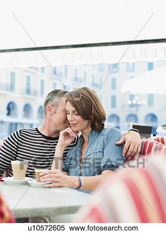 Stock Photography - couple sitting in a city cafe smiling. Fotosearch