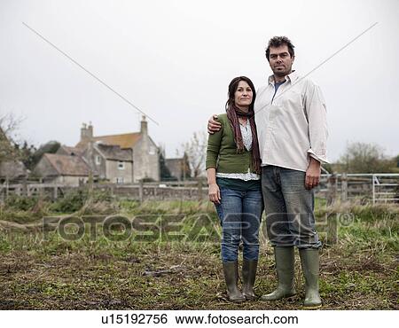 Stock Photograph - couple standing in front of farm house. Fotosearch