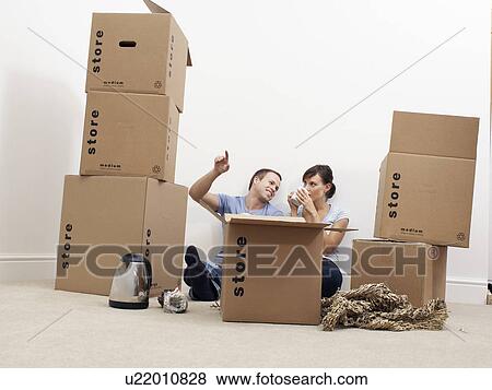Couple surrounded by moving boxes View Large Photo Image Stock Photo - Couple surrounded by moving boxes. Fotosearch
