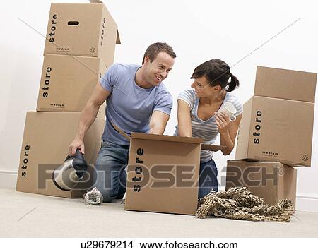 Picture - Couple unpacking kitchenware from boxes. Fotosearch
