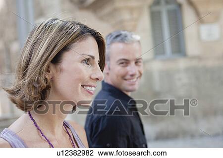 Stock Image - couple walking along the street. Fotosearch