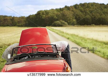 Couple with car, broken down View Large Photo Image Stock Photo - Couple with car, broken down. Fotosearch