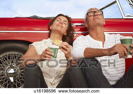 Couple with car, coffee break View Large Photo Image Stock Photograph - Couple with car, coffee break. Fotosearch