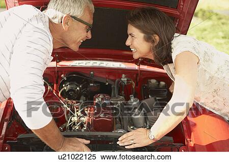 Couple with car, fixing engine View Large Photo Image Stock Photography - Couple with car, fixing engine. Fotosearch