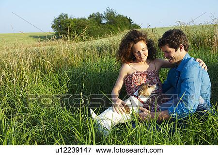 Stock Photo - Couple with dog, in a wheat field. Fotosearch