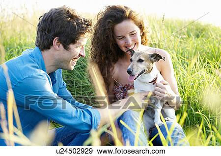 Stock Photo - Couple with dog in a wheat field. Fotosearch
