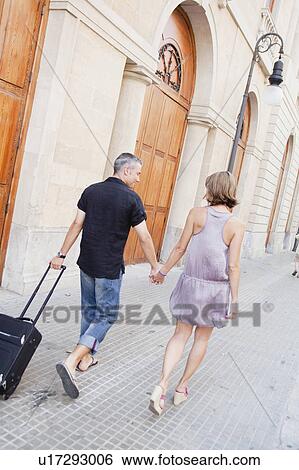 couple with trolly walking along street View Large Photo Image Stock Photograph - couple with trolly walking along street. Fotosearch