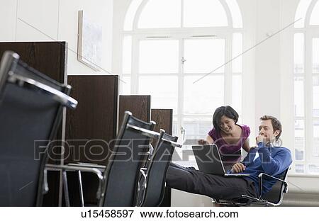 Stock Photo - Couple working together at a workstation. Fotosearch