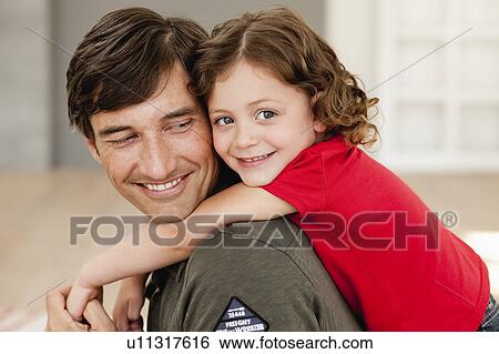 Stock Photograph - daughter riding on father's back. Fotosearch