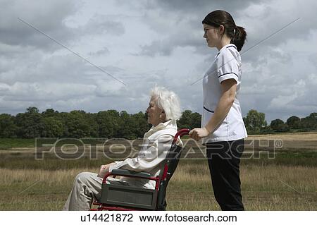Elderly woman in wheelchair with nurse View Large Photo Image Stock Image - Elderly woman in wheelchair with nurse. Fotosearch