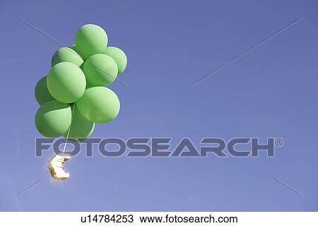 Stock Image - Euro flying with green helium balloons. Fotosearch
