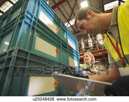 Stock Photo - Factory Workers Inspecting Crates. Fotosearch