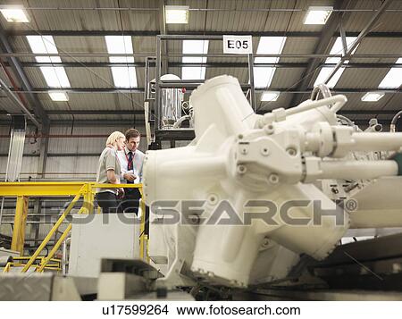 Picture - Factory Workers Looking At Machine. Fotosearch