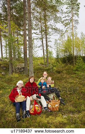 Stock Photo - Family with mushroom baskets in forest. Fotosearch