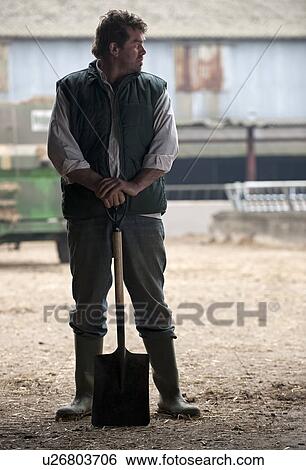 Stock Photograph - farmer relaxing with shovel. Fotosearch