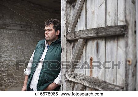 Stock Photography - farmer standing in barn. Fotosearch