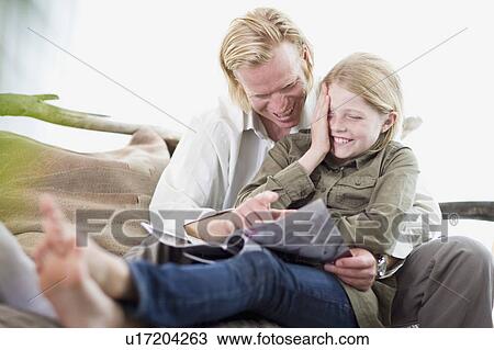 father and daughter reading a magazine View Large Photo Image Stock Image - father and daughter reading a magazine. Fotosearch