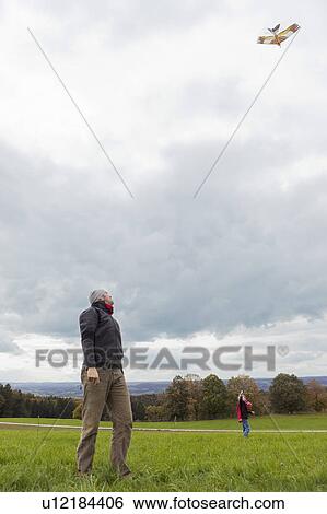 Father and son fly a kite View Large Photo Image Stock Photograph - Father and son fly a kite. Fotosearch