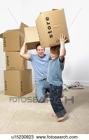Stock Image - Father and son playing with moving boxes. Fotosearch