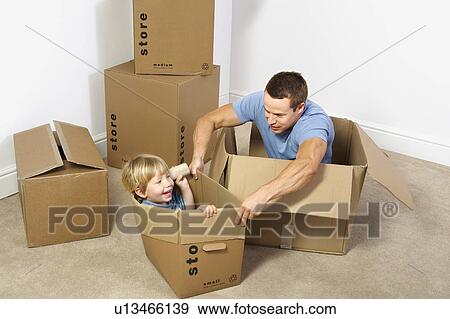 Stock Photo - Father and son playing with moving boxes. Fotosearch