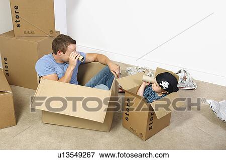 Stock Photo - Father and son playing with moving boxes. Fotosearch