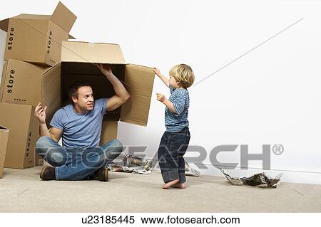 Stock Photography - Father and son playing with moving boxes. Fotosearch