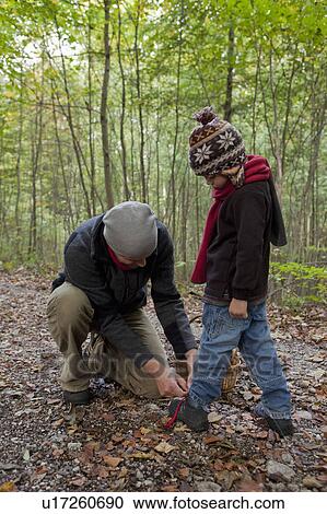 Stock Image - Father fastens sons shoes. Fotosearch