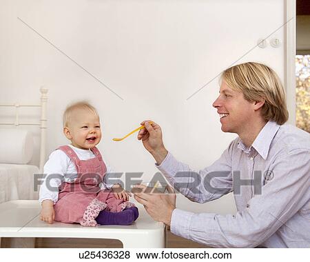 Stock Photo - father feeding baby. Fotosearch