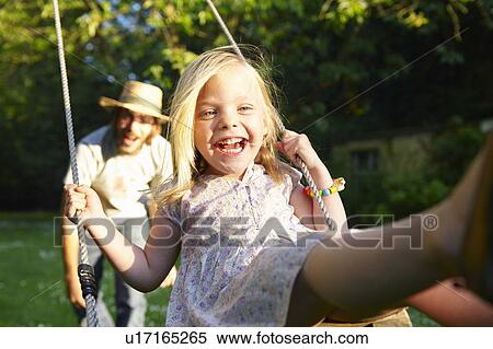 Stock Photography - Father pushing his girl on the swing. Fotosearch