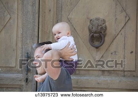 Stock Image - father with baby on shoulders. Fotosearch