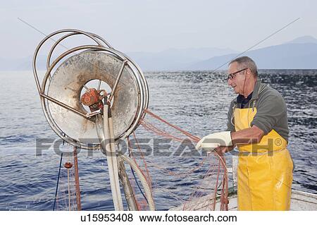 Stock Photo - fisherman on boat, trawling. Fotosearch
