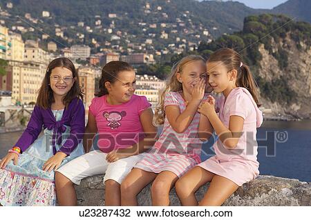 four girls on wall, two girls whispering View Large Photo Image Stock Image - four girls on wall, two girls whispering. Fotosearch