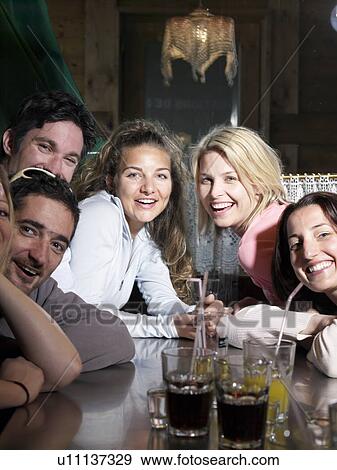 Stock Photo - friends drinking in ski lodge bar. Fotosearch