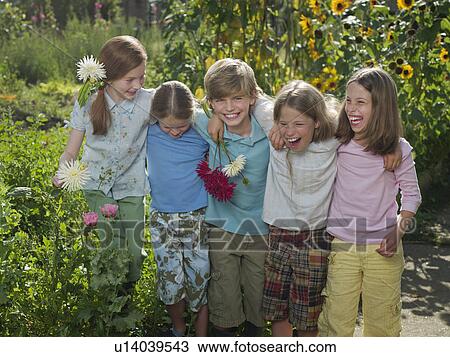 Stock Image - Friends smiling together in a garden. Fotosearch