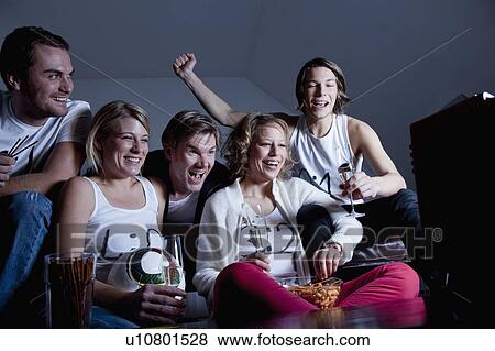 Stock Photo - friends watching TV together. Fotosearch