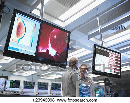 Stock Photo - Fusion Reactor Scientists With Screens. Fotosearch
