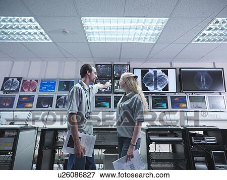 Stock Photo - Fusion Reactor Scientists With Screens. Fotosearch