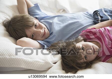 Girl and boy on bed View Large Photo Image Picture - Girl and boy on bed. Fotosearch
