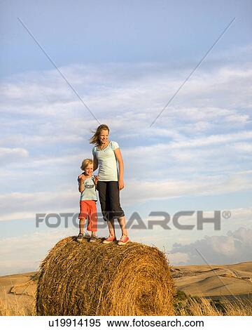 girl and boy standing on hay bale View Large Photo Image Stock Photography - girl and boy standing on hay bale. Fotosearch