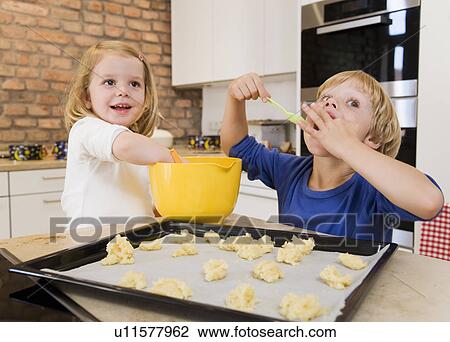 Stock Image - girl, boy preparing cookies for baking. Fotosearch