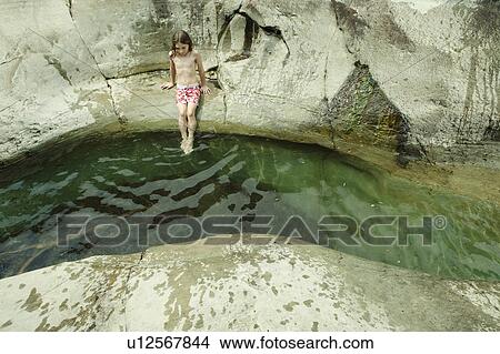 Picture - Girl dipping feet into stream. Fotosearch
