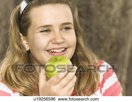 Stock Photograph - Girl eating apple. Fotosearch
