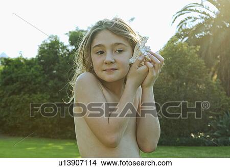 Girl holding shell to ear View Large Photo Image Picture - Girl holding shell to ear. Fotosearch