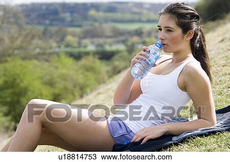 Stock Image - girl in countryside drinking water. Fotosearch