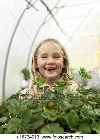 Stock Image - Girl in green house. Fotosearch
