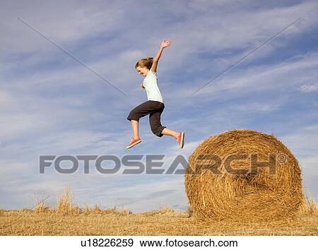 girl jumping from hay bale View Large Photo Image Stock Photo - girl jumping from hay bale. Fotosearch