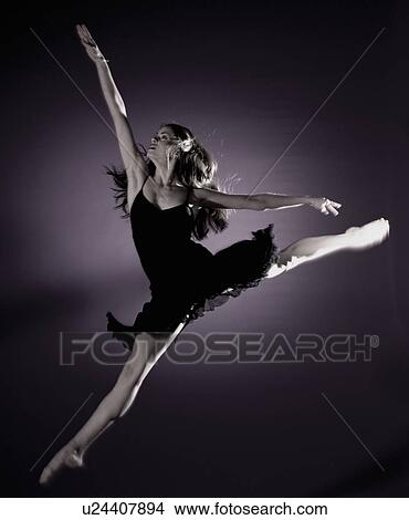 Picture - girl jumping in spotlight. Fotosearch