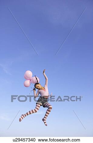 Girl jumping in the air with balloons View Large Photo Image Stock Image - Girl jumping in the air with balloons. Fotosearch