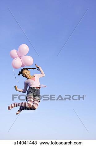 Girl jumping in the air with balloons View Large Photo Image Stock Photo - Girl jumping in the air with balloons. Fotosearch